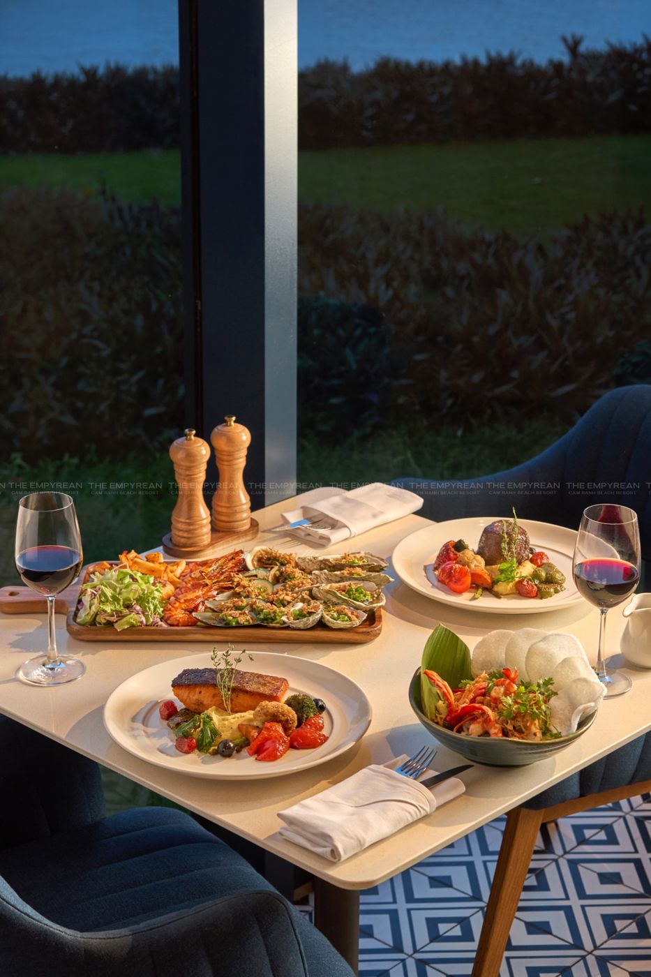 Grilled seafood, salmon and red wine on a table at dusk